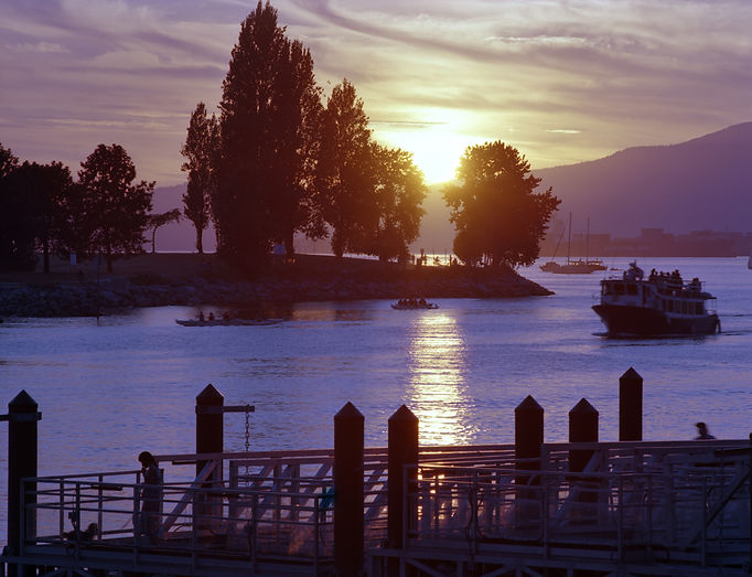 Boats coming in from English Bay before the sun sets behind the mountain