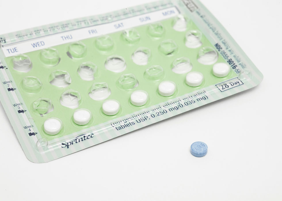 Green birth control blister pack with white pills, labeled days of the week, and a separate blue round pill on a white background.