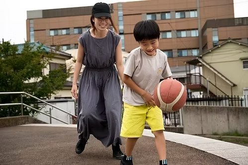single mom playing basketball with son