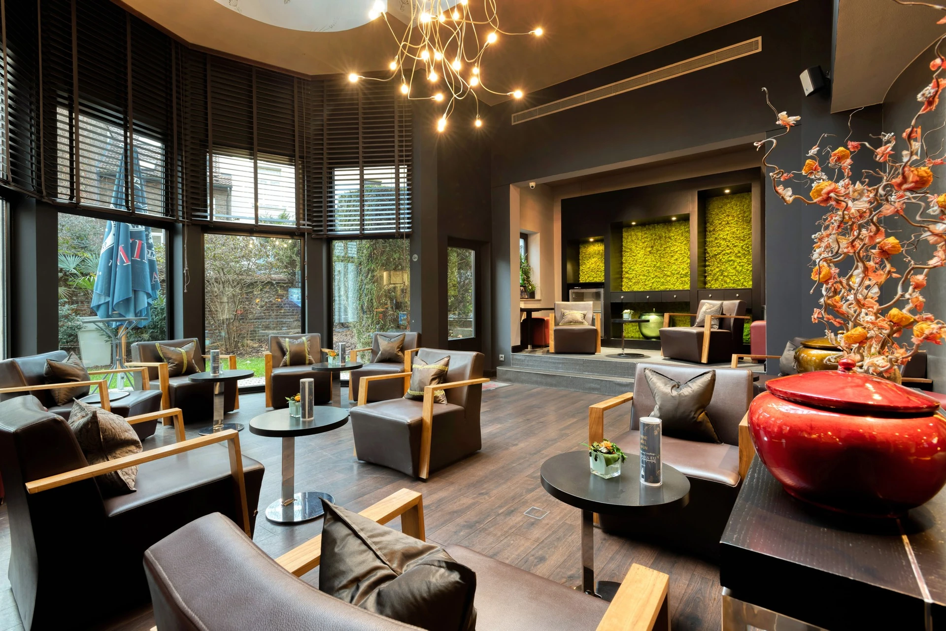 Cozy lounge space with armchairs and coffee tables in a contemporary 4‑star hotel.