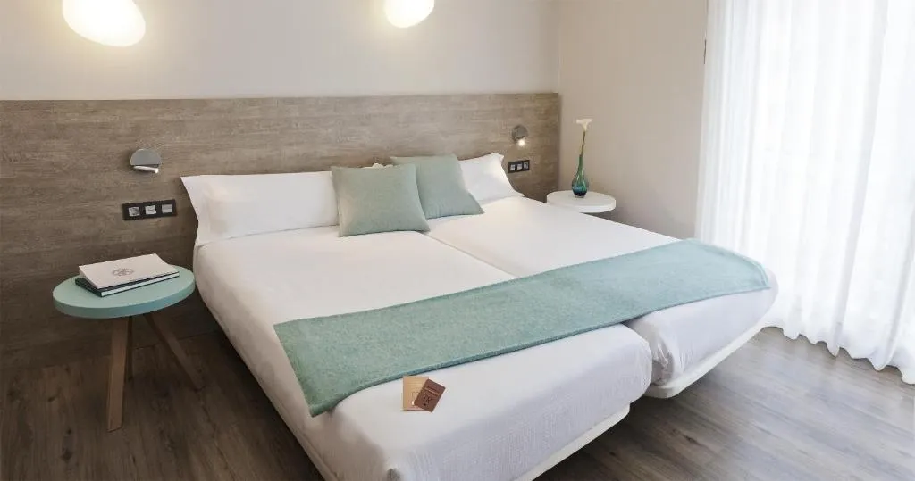 Minimalist twin‑room design with simple touches—clean and no extras, but dependable