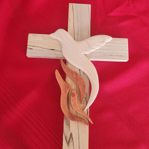 Wooden cross featuring a raised dove design.