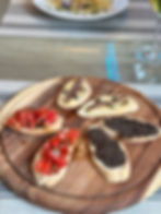 Bruschette miste, pomodoro, paté di olive, burro e acciughe