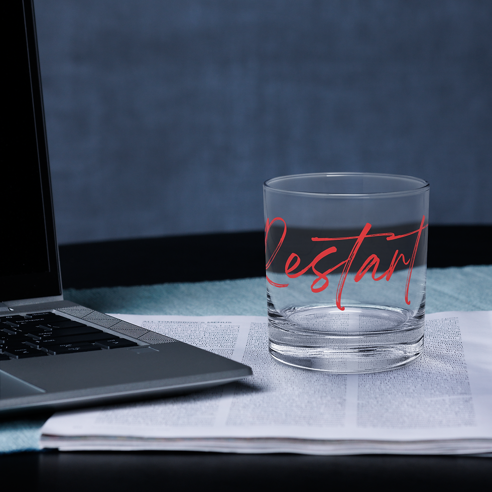 'Restart' glass on a desk next to a laptop