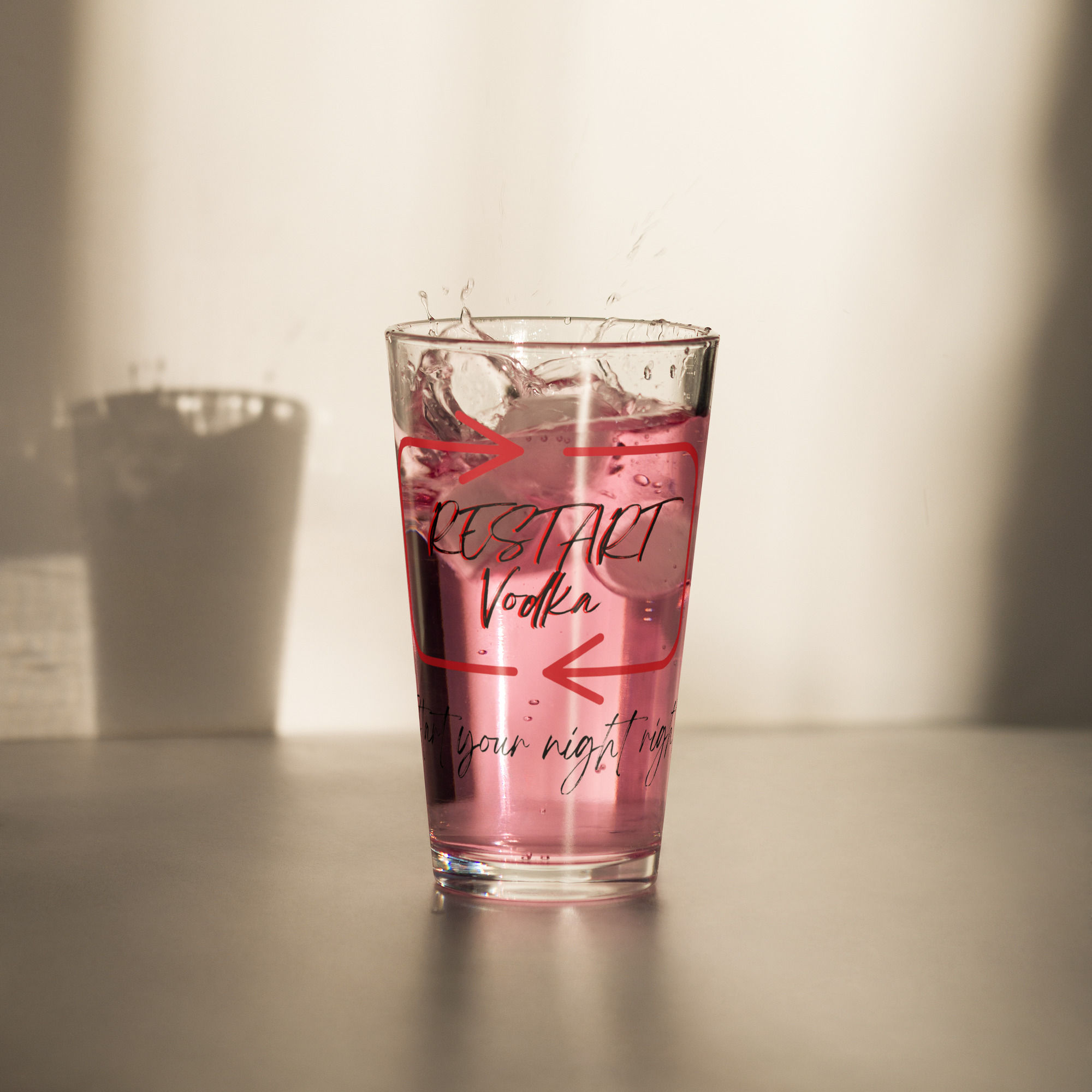 Pink drink splashing in a Restart Mixer Glass.