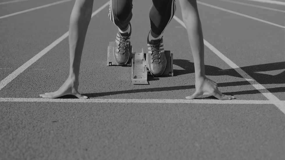 Professional athlete at the starting line preparing for a race, symbolizing leadership development, executive coaching, career transitions, and readiness for the next level of growth.