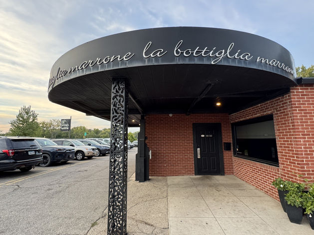 Exterior of the Brown Bottle restaurant with signage and red brick exterior against a blue sky