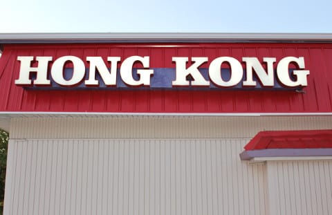 Exterior Restaurant sign with red backdrop and white letters that says Hong Kong