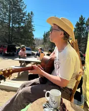 man playing a guitar outdoors