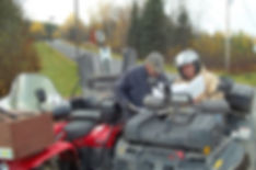 two men on ATVs reading a map