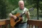 man playing the guitar outdoors