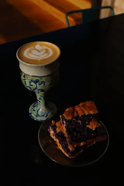 coffee drink with a piece of blueberry dessert