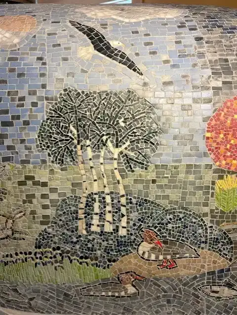 mosiac depicting trees, birds and fish