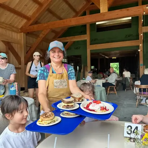 woman serving breakfast to children