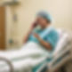 Photo of a patient in a hospital bed making a phone call with their mobile phone to an esc