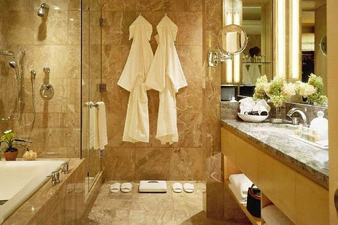 Hotel bathroom with robes, slippers, bathtub and sink