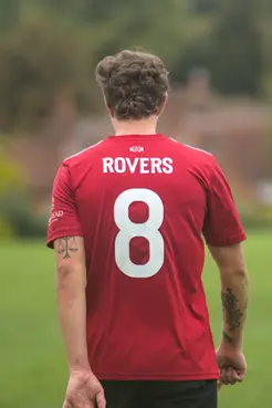 photograph of a footballer walking away from the camera with a number 8 on his shirt