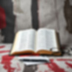 abstract background with a bible as the center focus. use black, white, red, gold muted co
