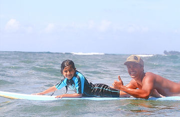 Instructor and same young kid sharing a longboard together