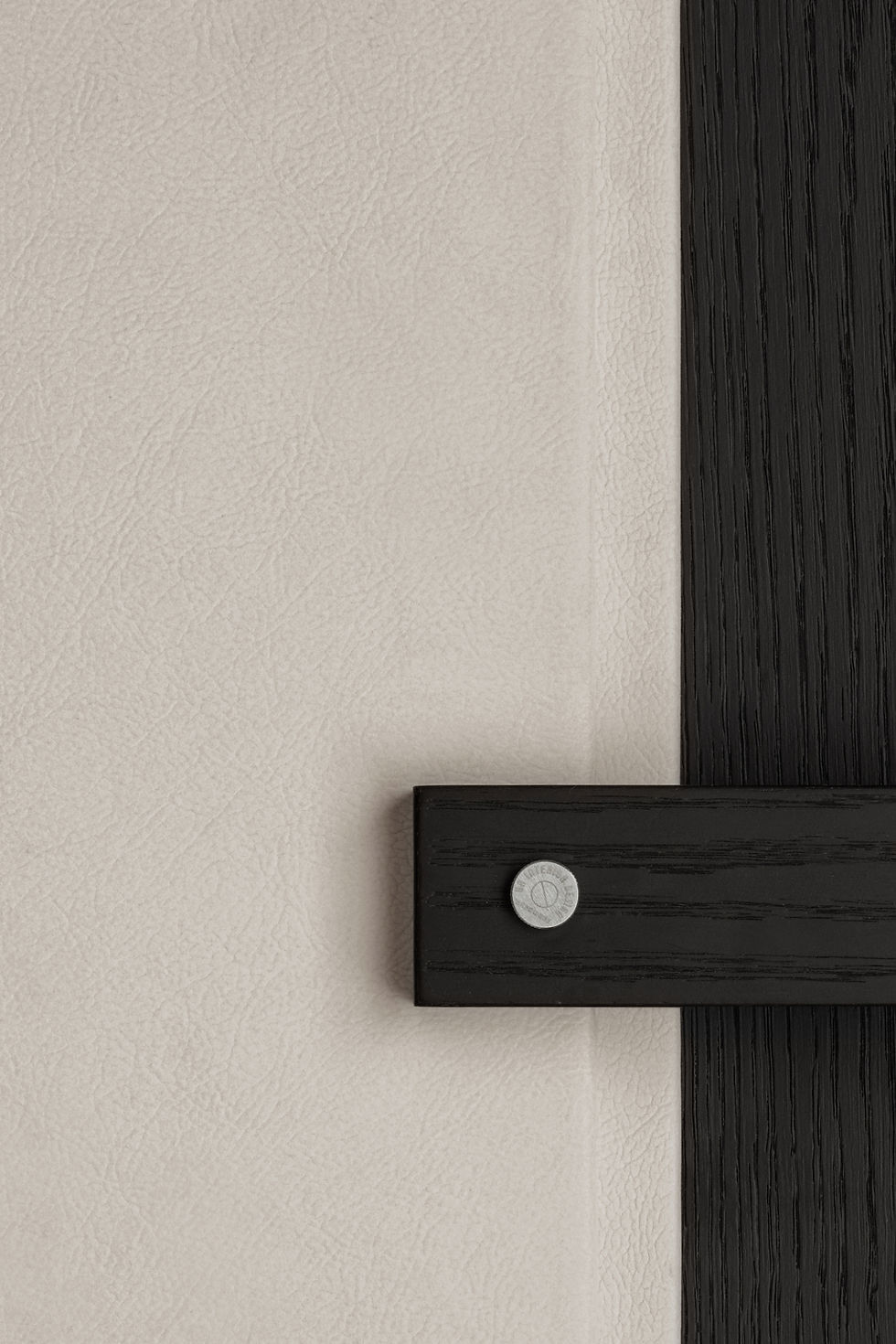 Close-up of a leather wall with a vertical black wooden strip intersected by a horizontal piece.