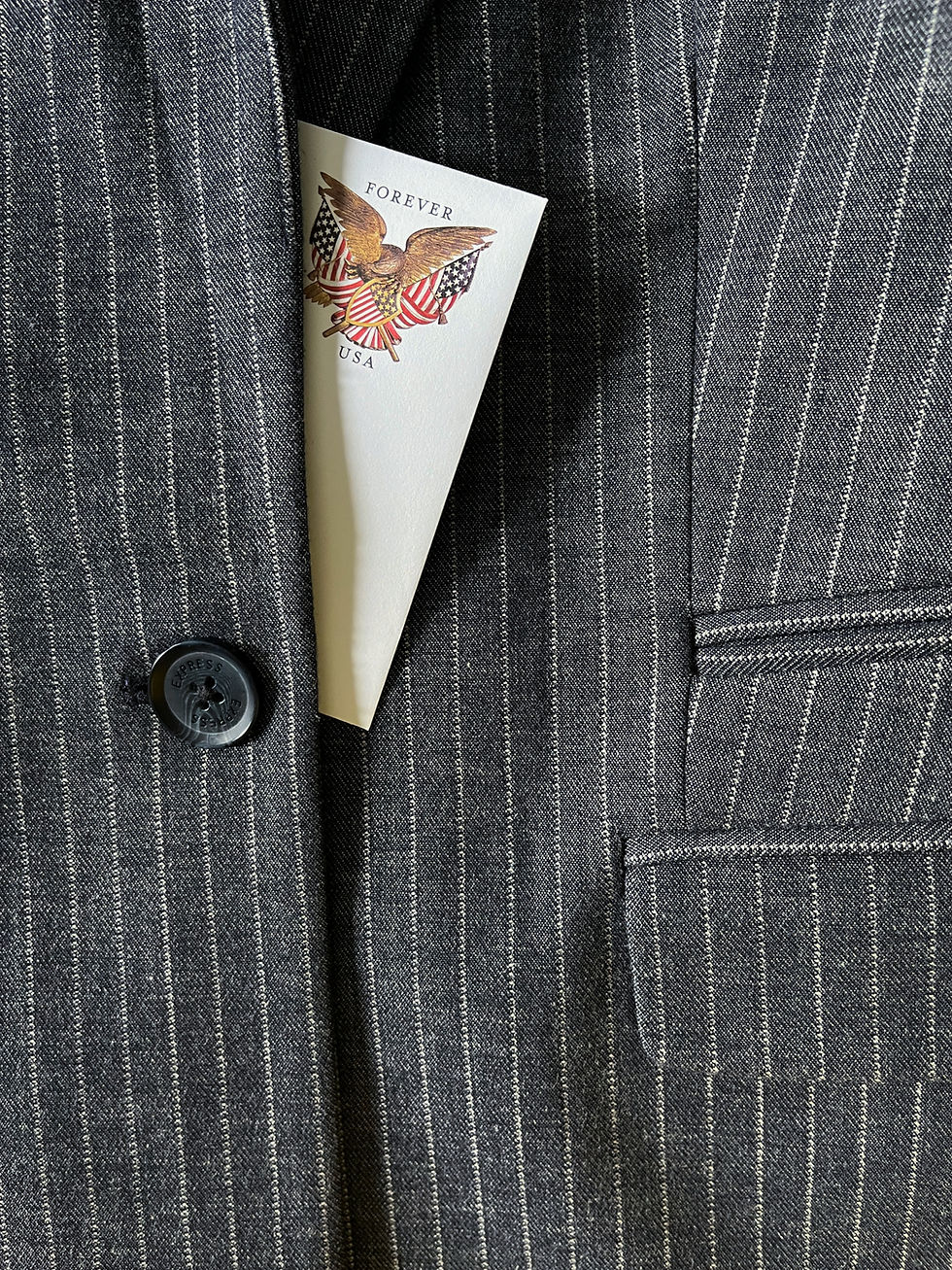 Pinstripe suit jacket with a button and pocket, holding a card with a bald eagle and US flags. Text reads "Forever USA."