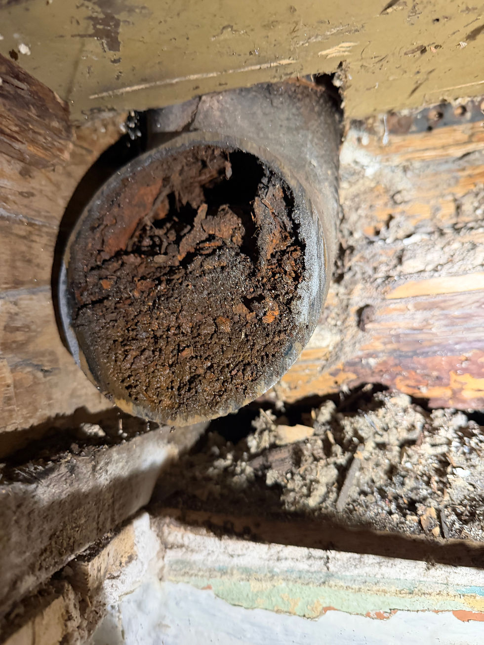 Severely corroded interior of old cast iron drain pipe