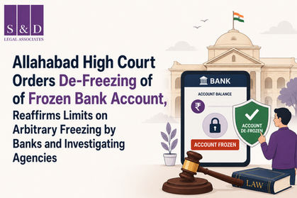 Minimalist legal-themed illustration depicting the Allahabad High Court's decision on de-freezing frozen bank accounts. The graphic features a courthouse backdrop, a smartphone banking interface displaying a frozen account, a green shield marked "Account De-Frozen," a judge's gavel, and a law book. The banner headline reads: "Allahabad High Court Orders De-Freezing of Frozen Bank Account, Reaffirms Limits on Arbitrary Freezing by Banks and Investigating Agencies." The S&D Legal Associates logo appears in the top-left corner.