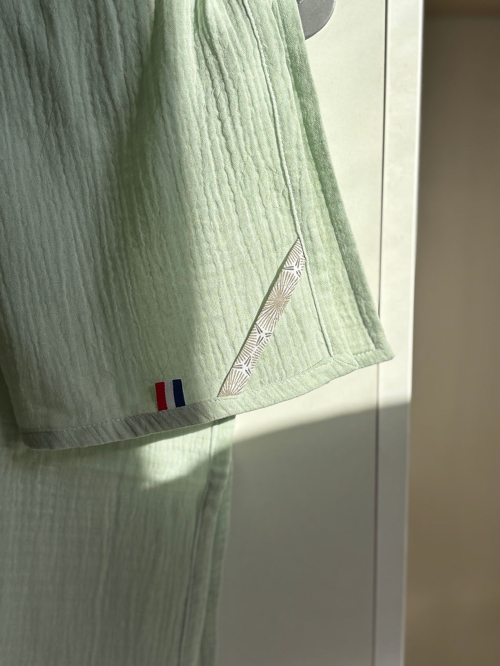 Détail d'un tissu vert pastel, avec un motif étoilé, drapeau tricolore. Calot chirurgical.
