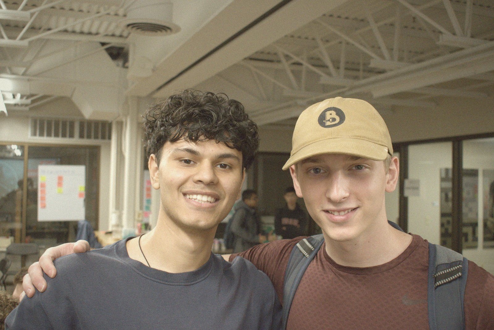 Two students smiling arm in arm at Build Night