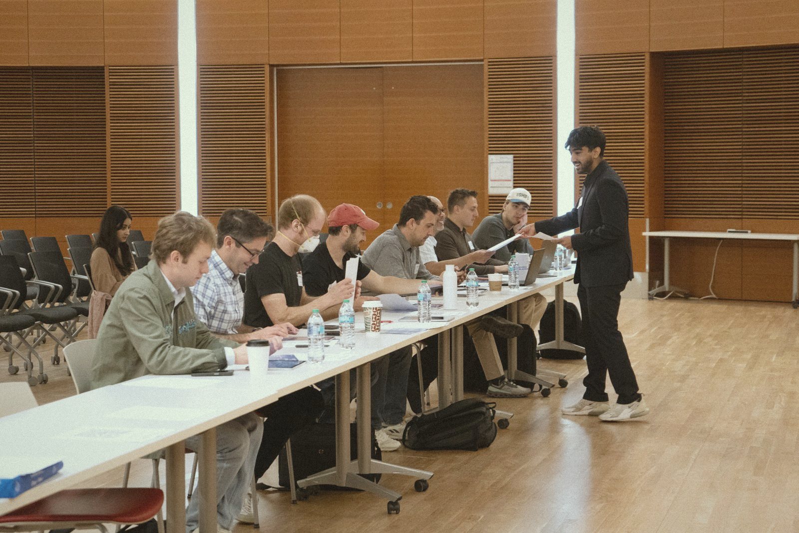 A student handing materials to a table of judges