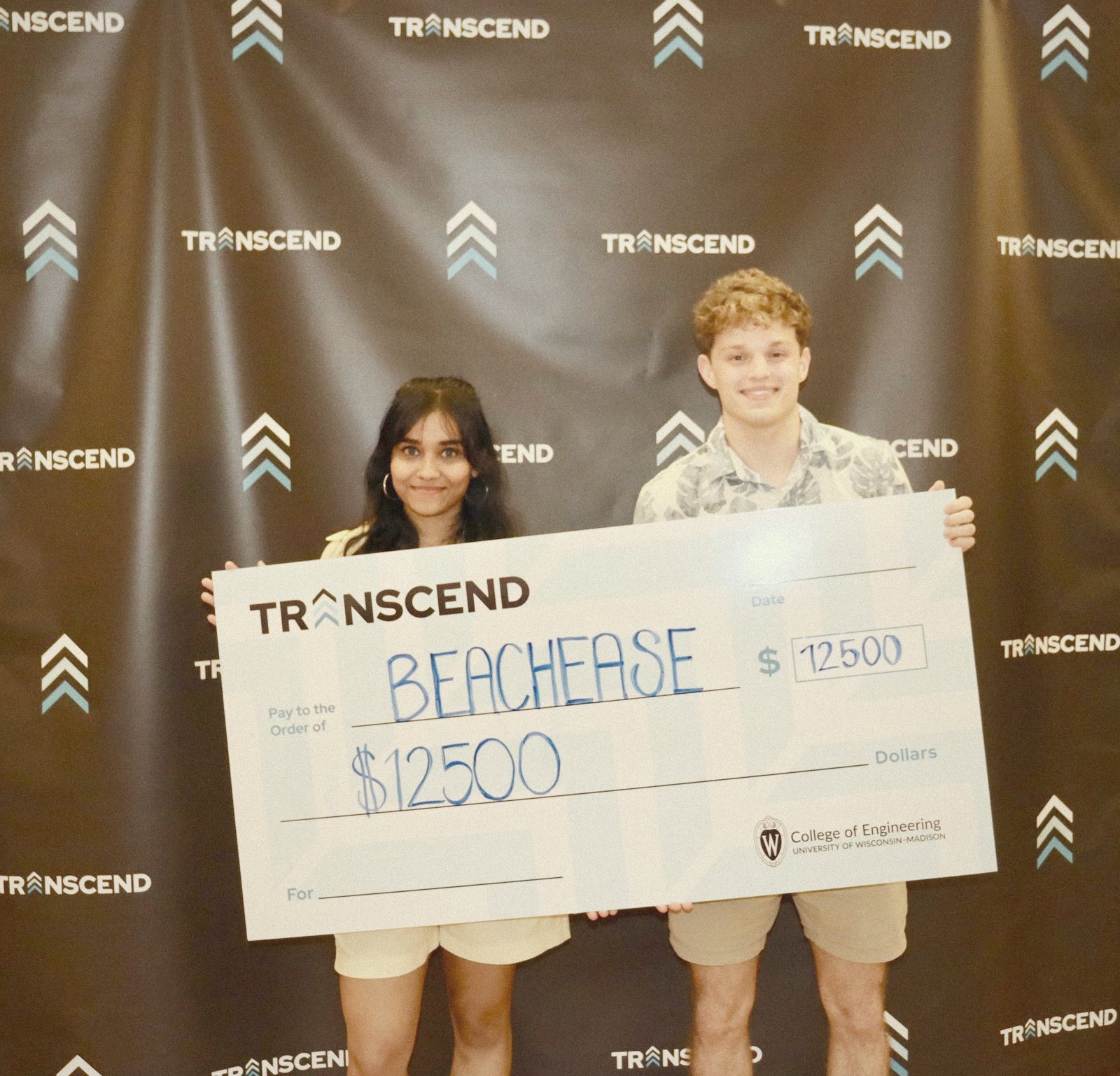 Two BeachEase founders holding a $12,500 Transcend check