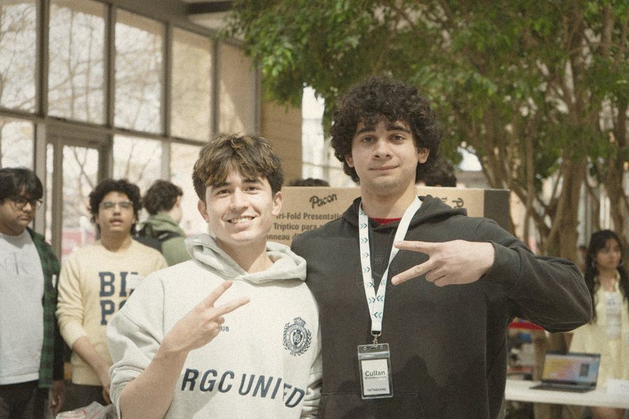 Two students throwing up peace signs at a Transcend expo