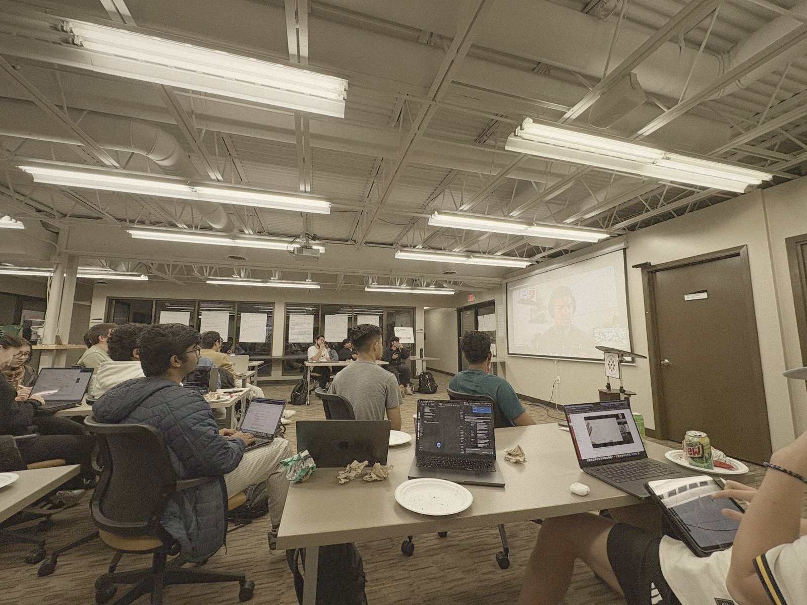 Students working with laptops during a Build Night talk