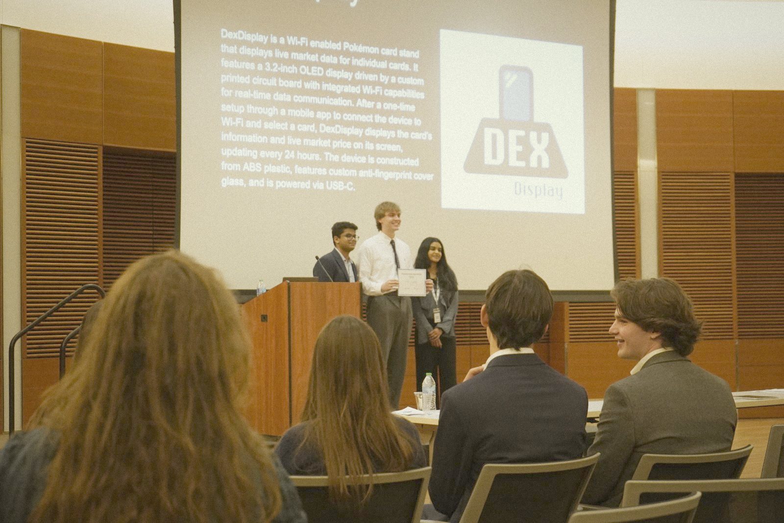DexDisplay team receiving an award on stage in front of their slide