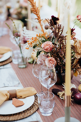 Elegant wedding reception table setting with pink roses and gold candles at intimate ceremony