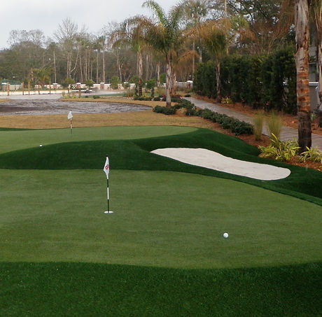 Synthetic turf putting green with sand trap and flags