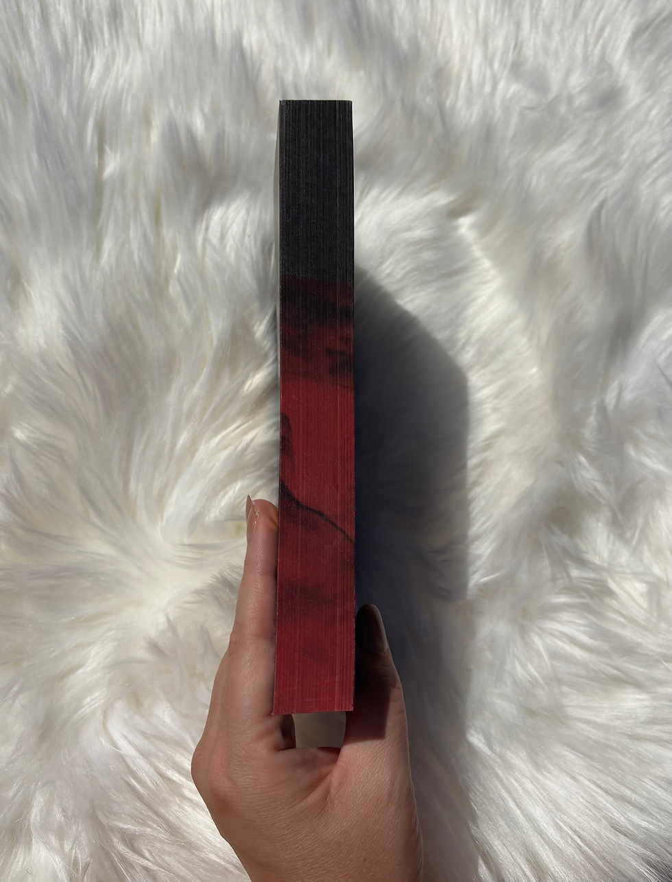 Book spine with red and black design held on white fur background.