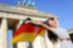 German flag - Woman happy at Berlin Brandenburg Gate cheering celebrating waving flag by B