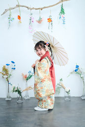 3歳の女の子が和傘を持って、お花と七五三の撮影している