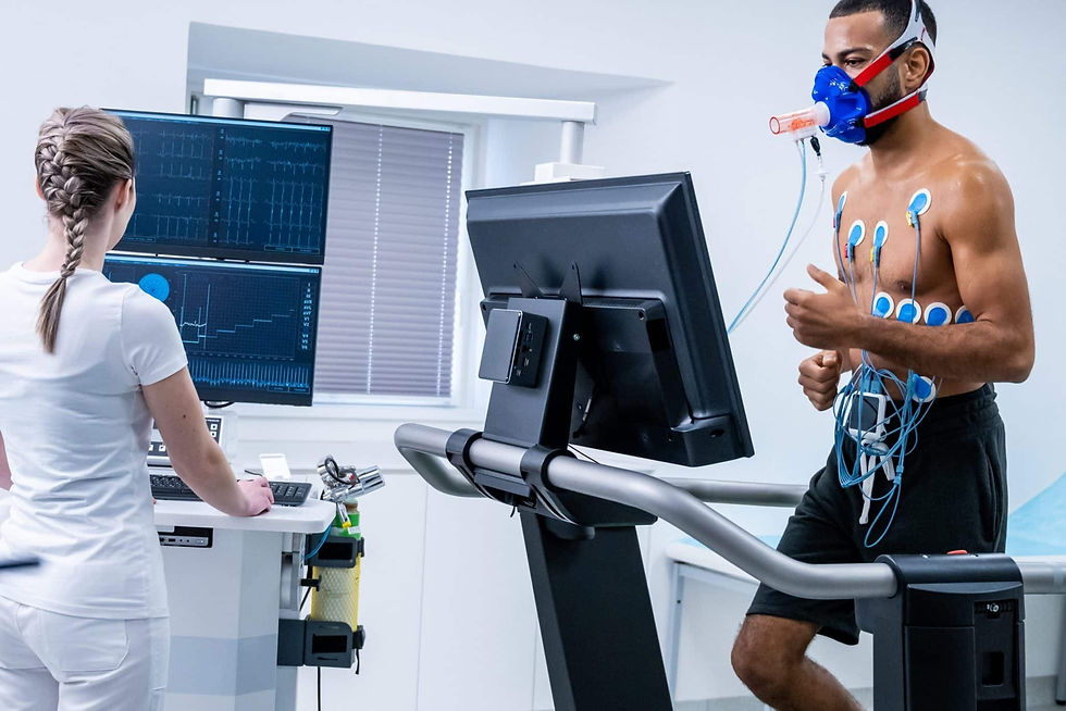 Paciente corre em teste cardiopulmonar, com máscara respiratória e eletrodos, enquanto técnica monitora gráficos em sala clínica.