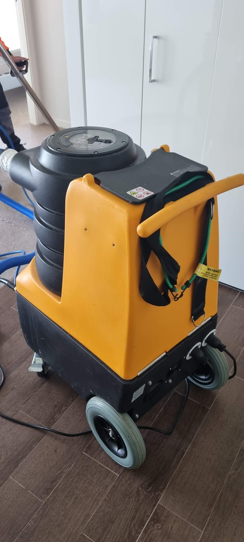Image of a technician performing water extraction on carpets in one of the unit