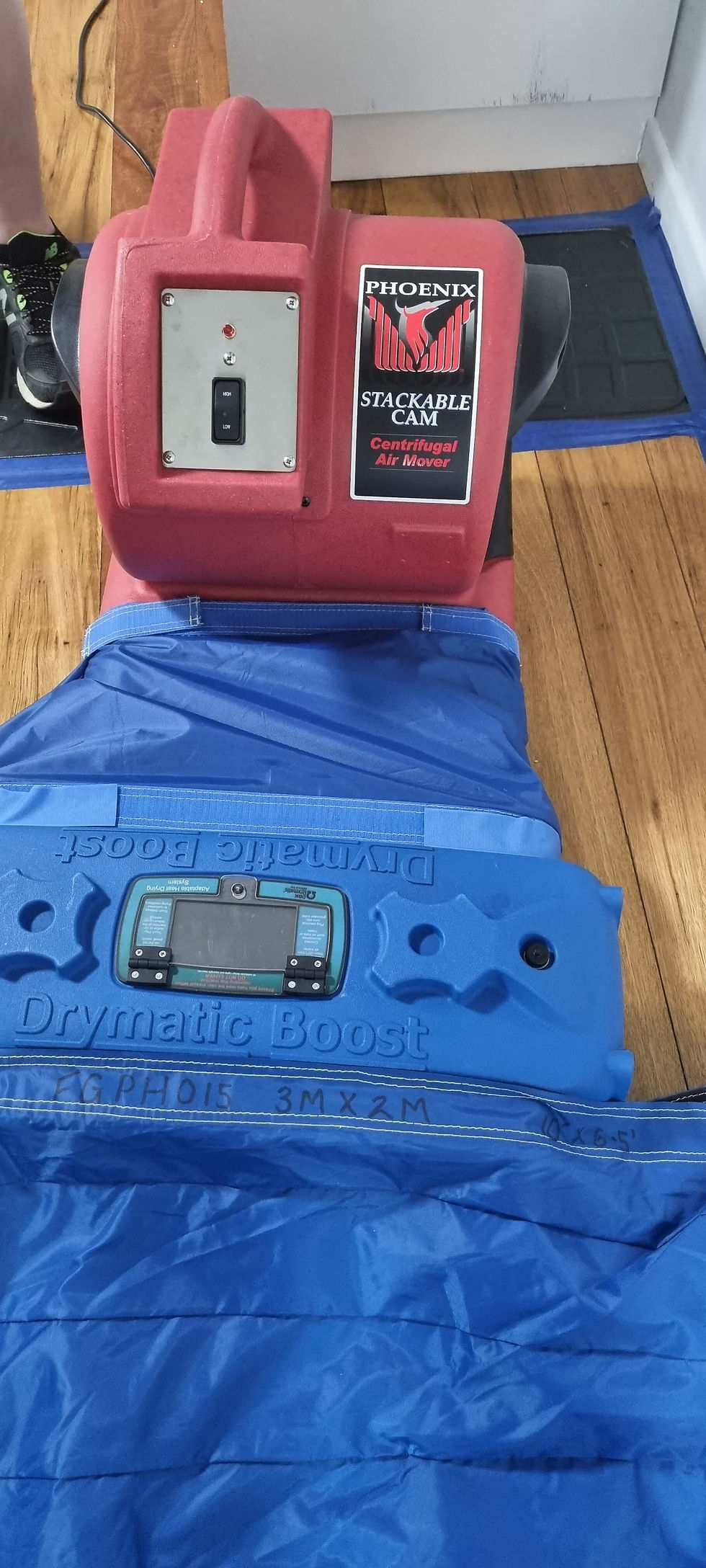 a fan connecting to a drymatic heater and heat mats drying a timber floor