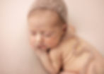 Sleeping baby in a soft knit hat, resting on a light pink blanket. The serene mood highlights the baby's peaceful expression.