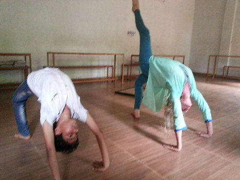 Yoga Instructor Rebecca Bachar teaching India orphan yoga pose the wheel, chakrasana or urdhva dhanurasana in Sanskrit.