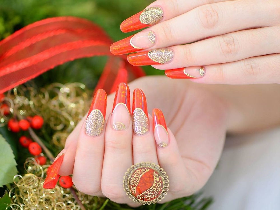 Lange rote Nägel mit goldenen Mustern und passendem Ring, festlich dekoriert mit roten Bändern.