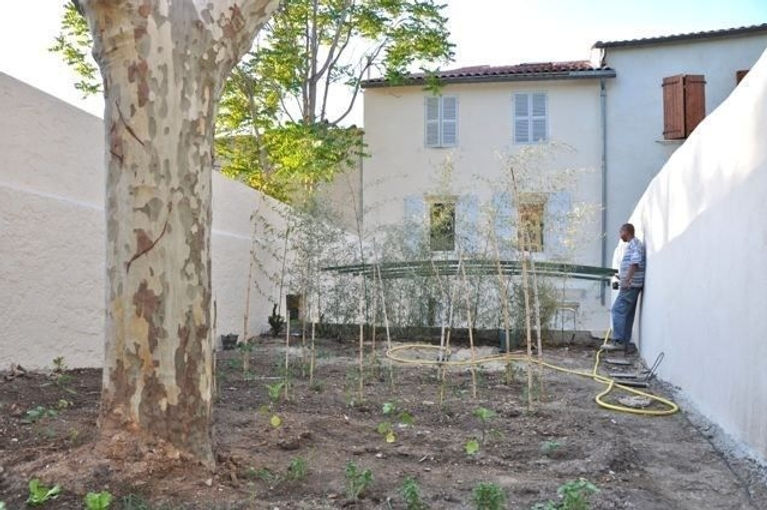 Vue de la cour vers le jardin potager de l'immeuble