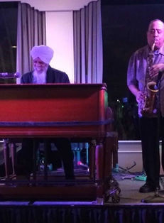 Band performing live with organ, saxophone, and guitar