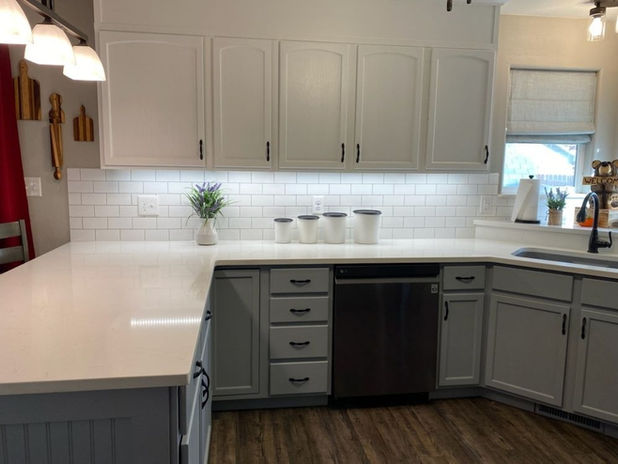Professional cabinet painting in Fruita, CO, featuring white upper cabinets and gray lower cabinets by Prime Painting Experts.