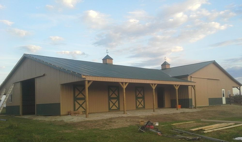 Large tan pole barn under a cloudy sky JC Pole Barns construction project