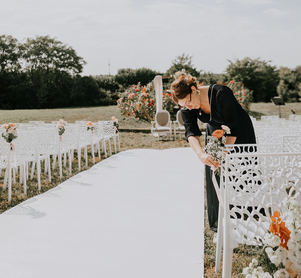 Une prestataire décoratrice de mariage qui installe des éléments de décoration pour la cérémonie laique